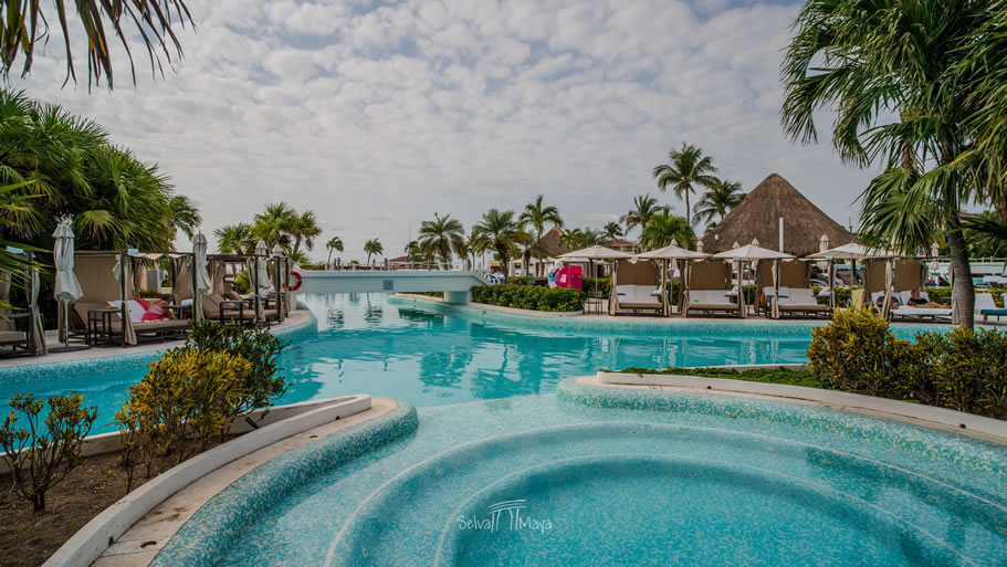 Jacuzzi exterior de Moon Palace Cancún junto a la alberca, con camas balinesas