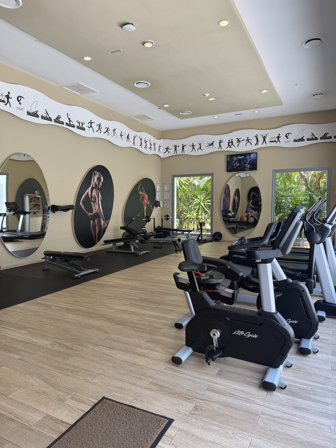 Gimnasio del Riu Tequila con bicicletas fijas, caminadoras y ventanales a los jardines