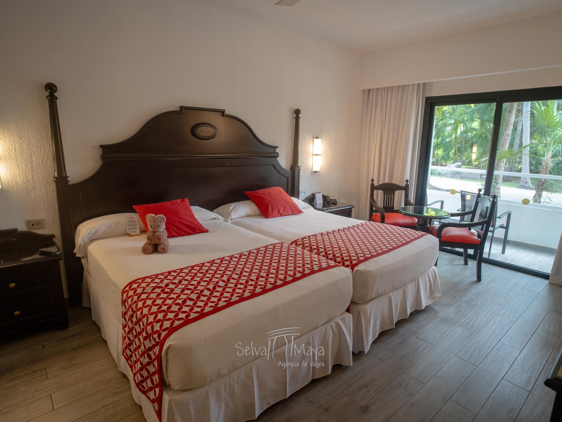 Habitación del Riu Tequila con dos camas, mesa redonda y salida a la terraza