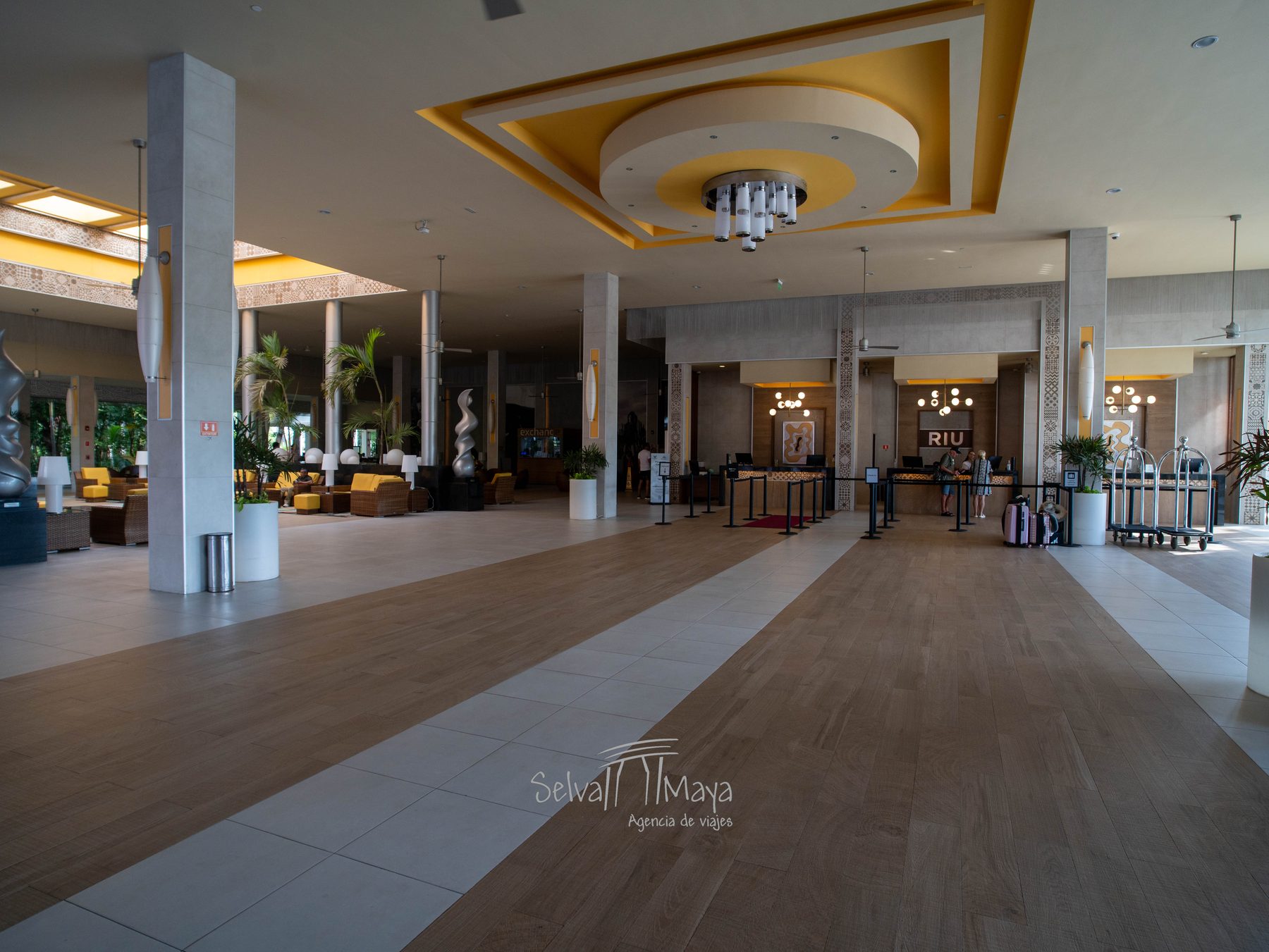 Lobby principal del Riu Tequila con plafón dorado, recepción y salas de estar