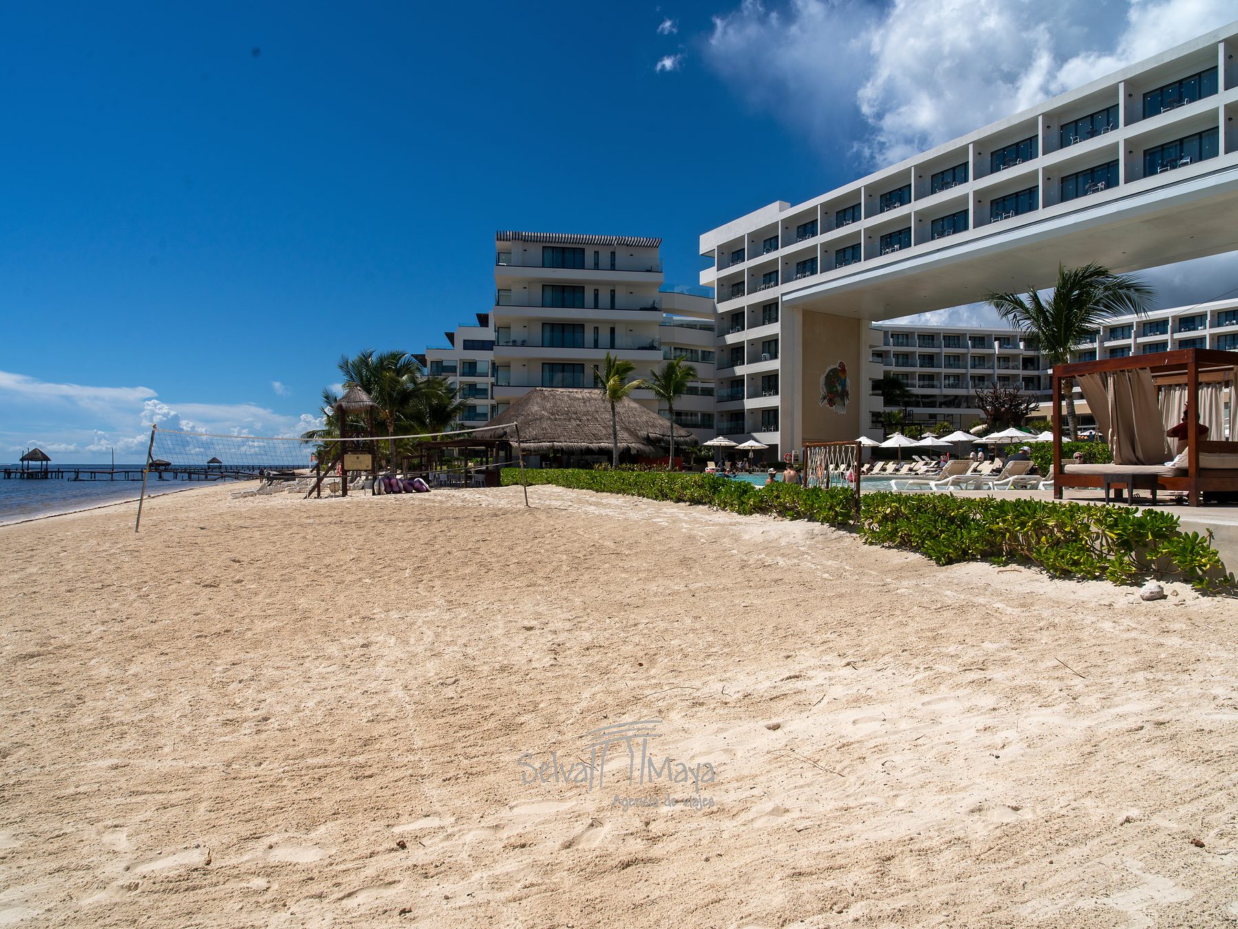 Playa de arena frente al edificio de habitaciones en Sensira Resort Riviera Maya
