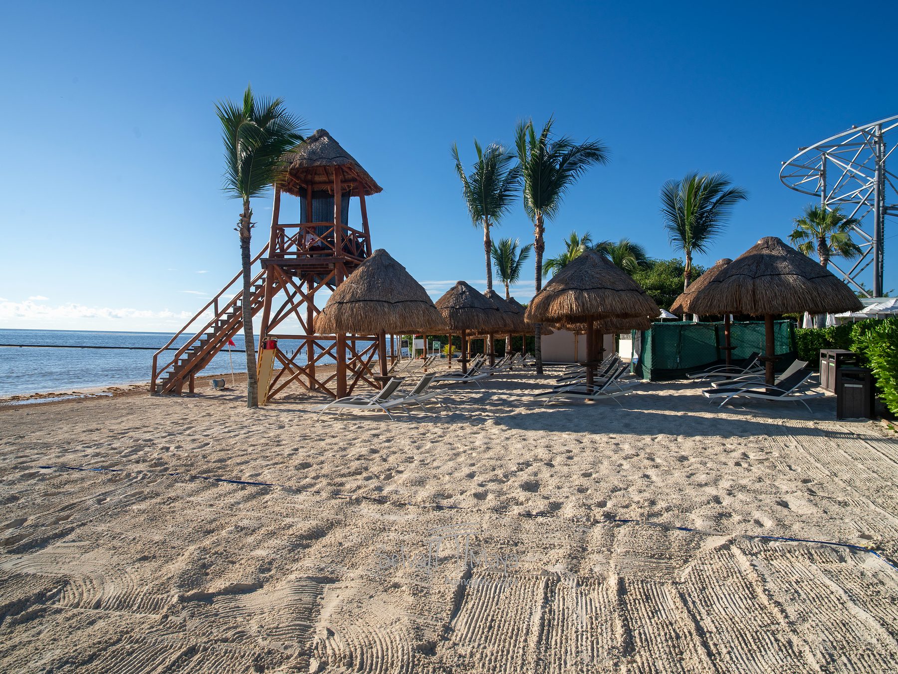Playa con palapas y torre de salvavidas en Dreams Natura Resort & Spa