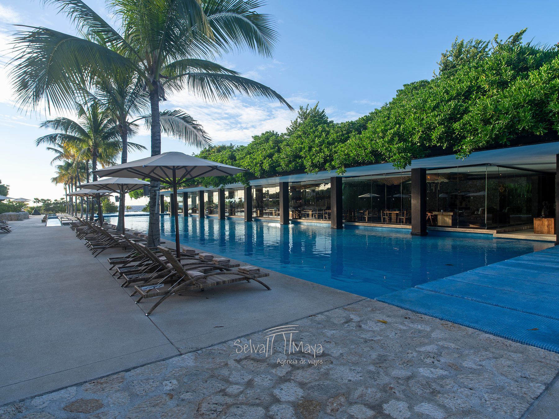Alberca infinita principal de Hotel Xcaret Arte con camastros