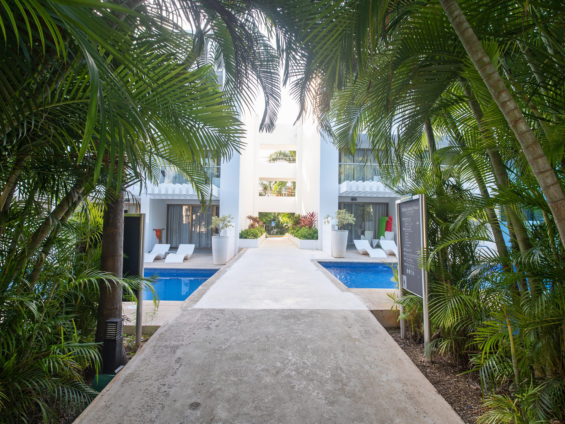 Acceso a un edificio de habitaciones entre palmeras en Platinum Yucatán Princess