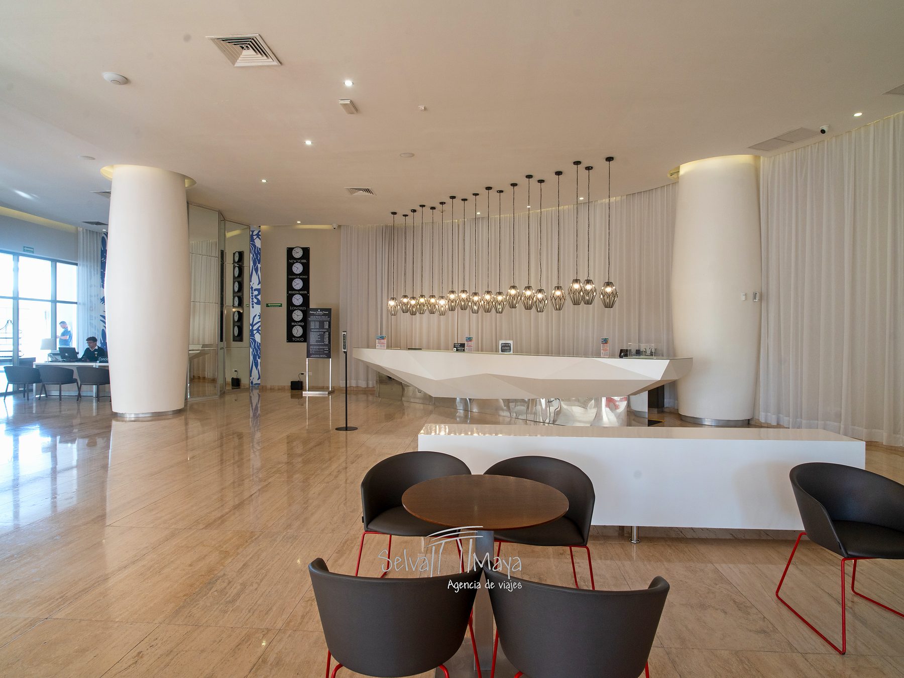 Lobby con recepción y lámparas colgantes en Platinum Yucatán Princess