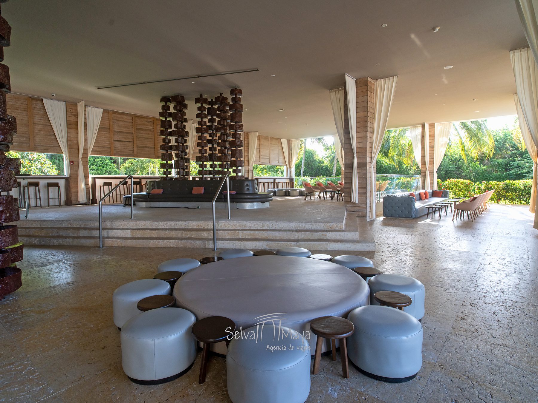 Salón del bar con mesa redonda y taburetes en Platinum Yucatán Princess