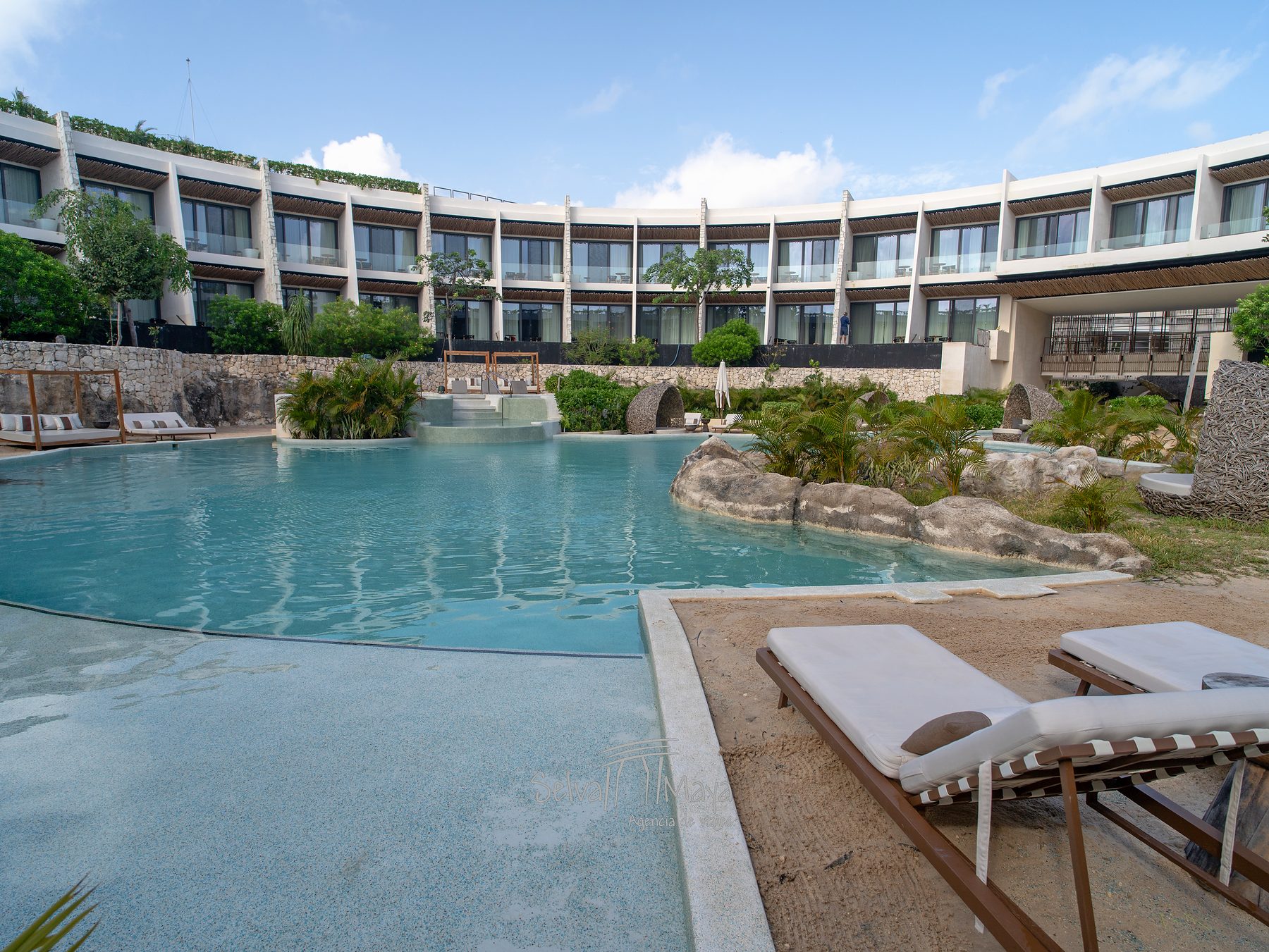 Alberca con camastros frente a las suites en Secrets Tulum