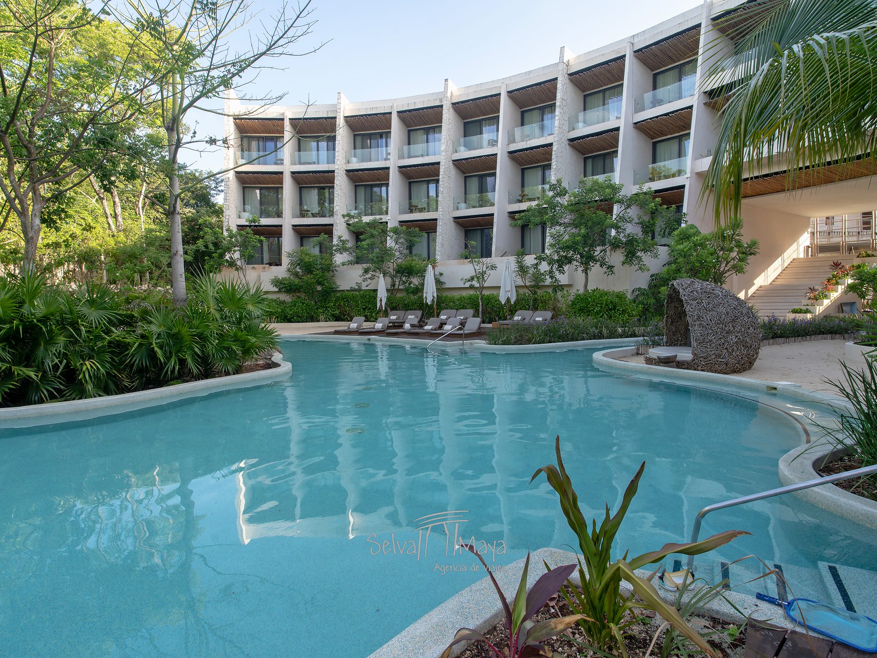 Alberca entre la selva y los edificios de suites en Secrets Tulum