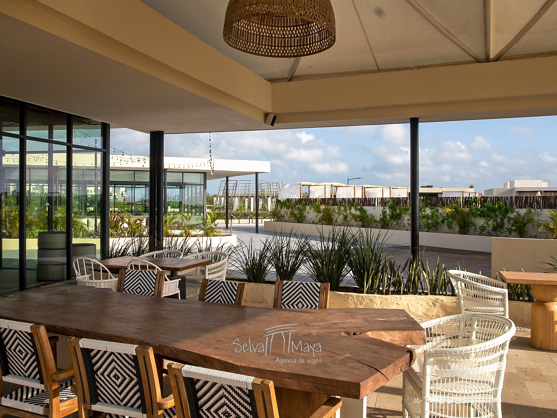 Terraza de restaurante con mesas de madera en Secrets Tulum