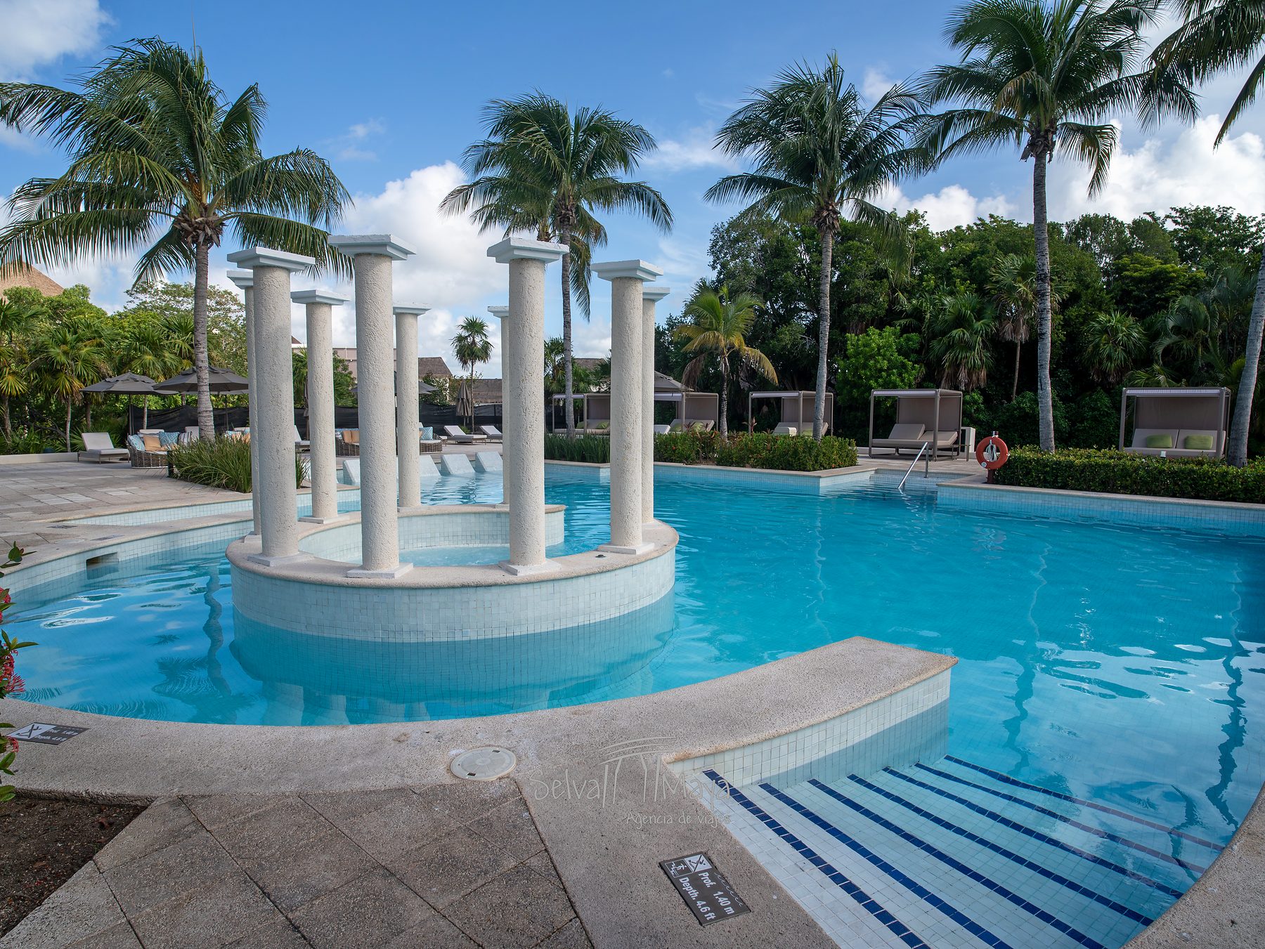 Alberca tranquila de La Terraza, con columnas entre palmeras en TRS Yucatán Hotel